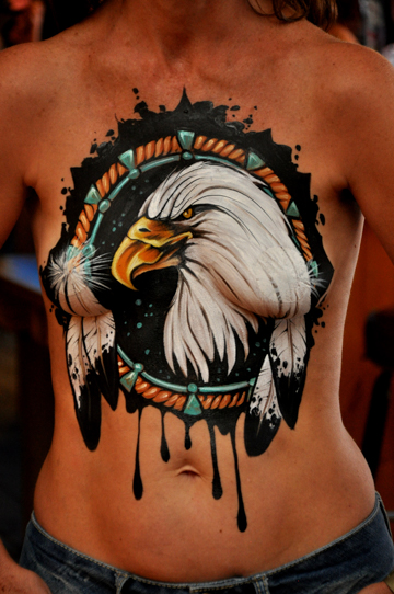 chest of a woman with a detailed body painting that resembles a dream catcher and has a bald eagle in the middle of it
